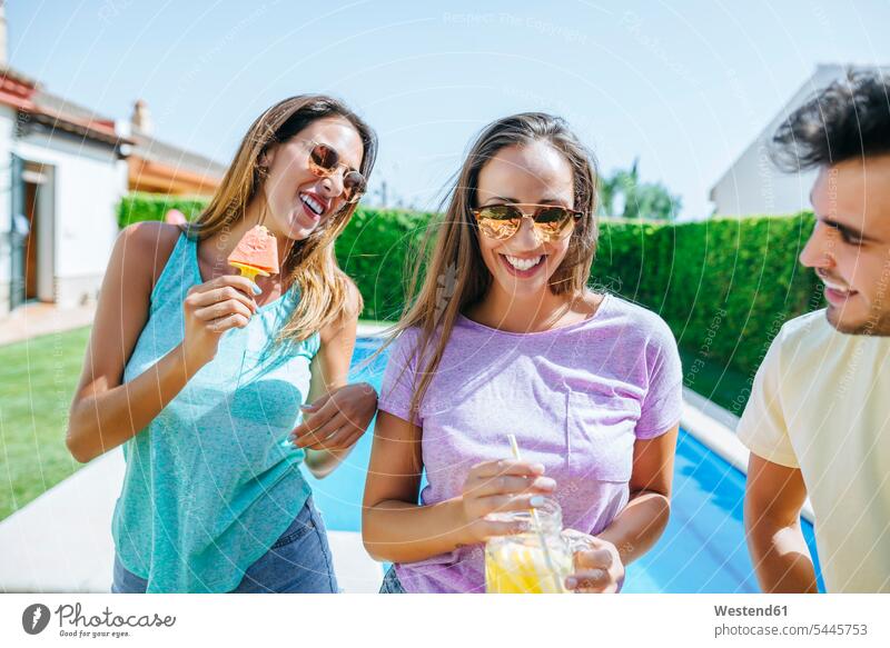 Happy friends with drink and watermelon at the poolside relaxed relaxation smiling smile happiness happy friendship relaxing swimming pool swimming pools
