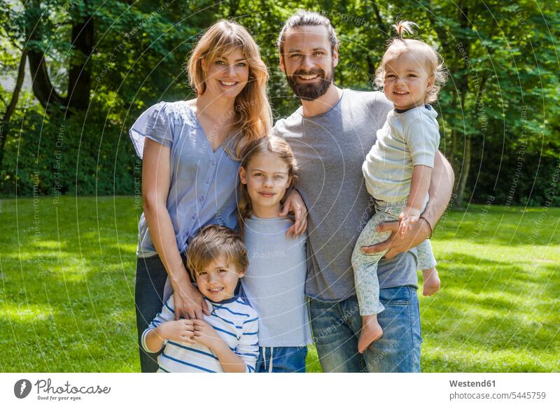 Portrait of happy family standing on meadow smiling smile meadows families people persons human being humans human beings daughter daughters happiness enjoying