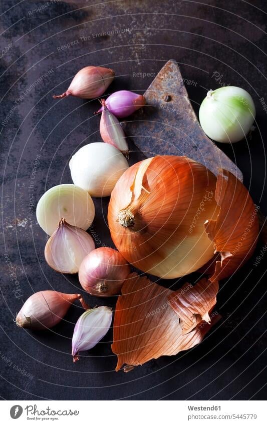 Various sorts of onions on rusty ground big various different sliced onion skin onion skins divers Brown Background brown whole dark background white onion