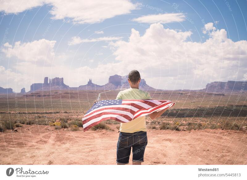 USA, Utah, back view of man with American Flag looking at Monument Valley males American Flags Flag of America Adults grown-ups grownups adult people persons