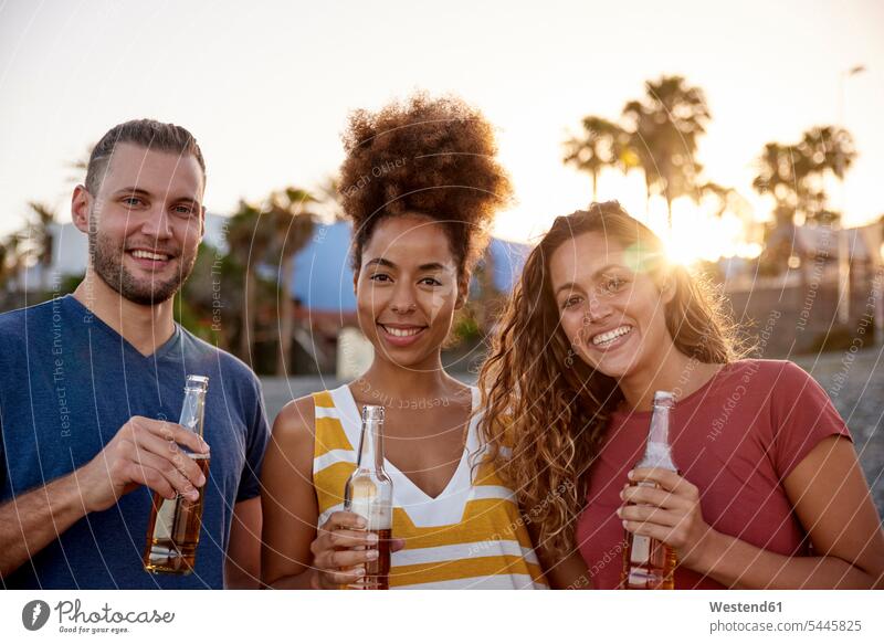 Group picture of three friends with beer bottles on the beach at sunset beaches Beer Beers Ale friendship Alcohol alcoholic beverage Alcoholic Drink