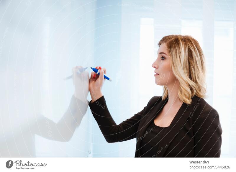 Businesswoman at whiteboard in office businesswoman businesswomen business woman business women boards presentation presentations offices office room