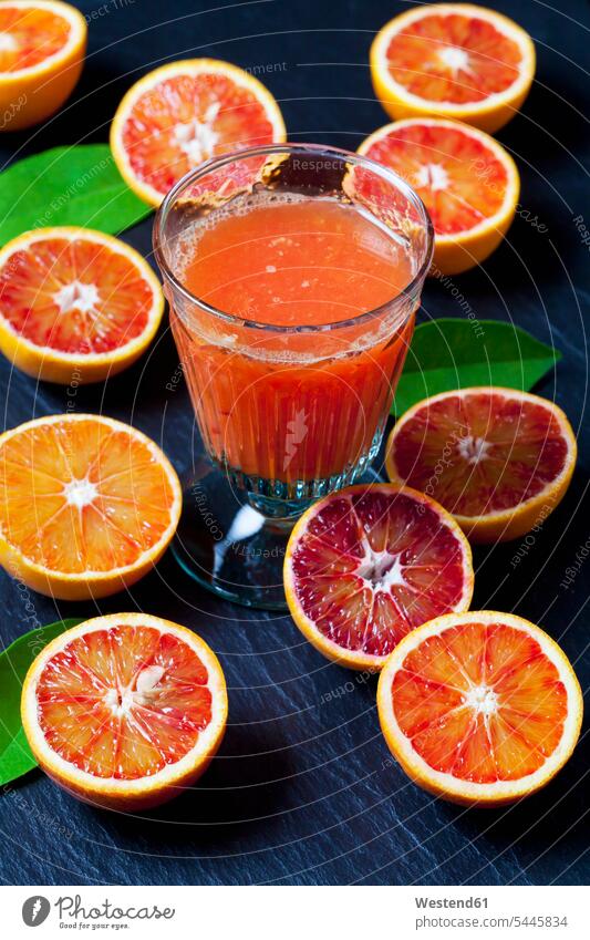 Sliced blood oranges and glass of orange juice on slate food and drink Nutrition Alimentation Food and Drinks Orange Citrus sinensis Oranges variation Leaf