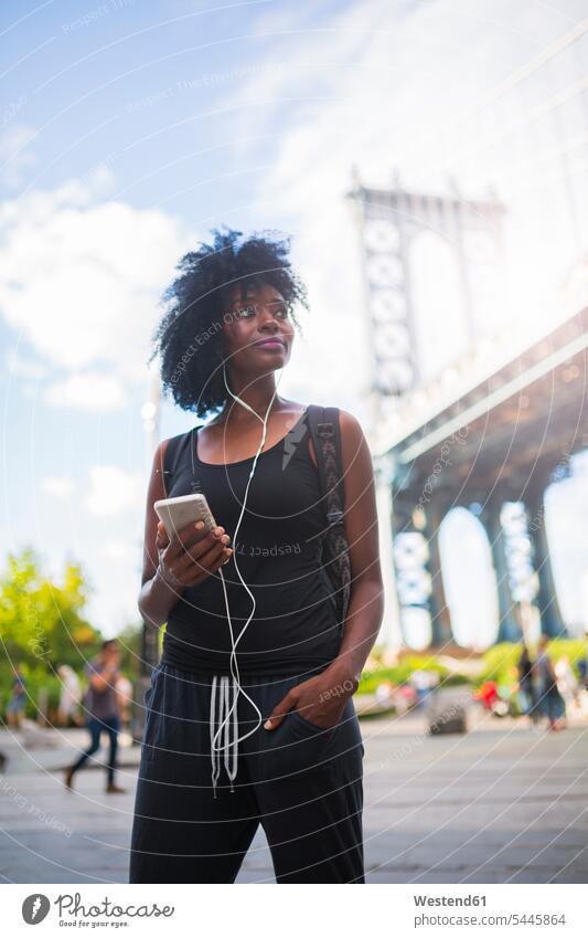 USA, New York City, Brooklyn, woman listening to music at Manhattan Bridge hearing females women Adults grown-ups grownups adult people persons human being