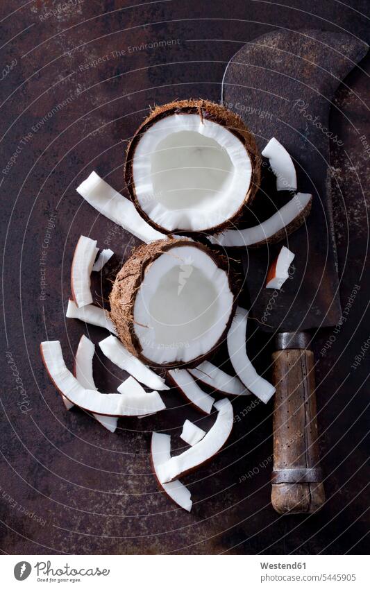 Opened coconut, cocontu pieces and an old cleaver brown peeled tropical Tropical Climate sliced arrangement grouping firm hollow opened Brown Background