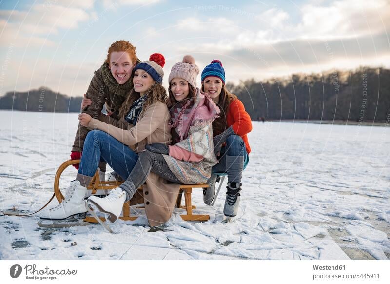 Friends having fun with sledge on frozen lake happiness happy laughing Laughter friends toboggans sledges positive Emotion Feeling Feelings Sentiments Emotions