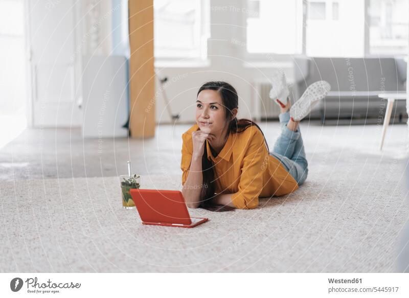 Young woman using laptop, lying on floor, thinking females women young Iced Tea carpet carpets rug rugs laying down lie lying down working At Work