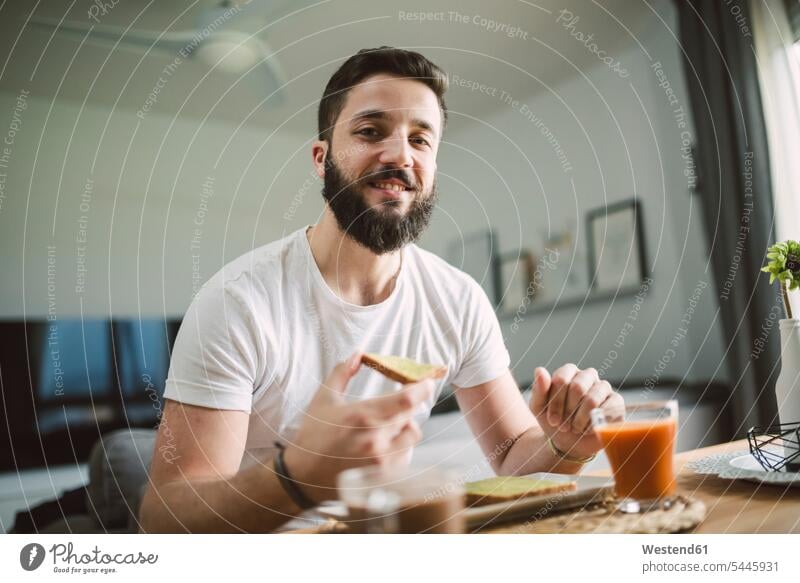 Portrait of young man having breakfast Toast toast bread Toasts men males smiling smile Bread Breads Food foods food and drink Nutrition Alimentation