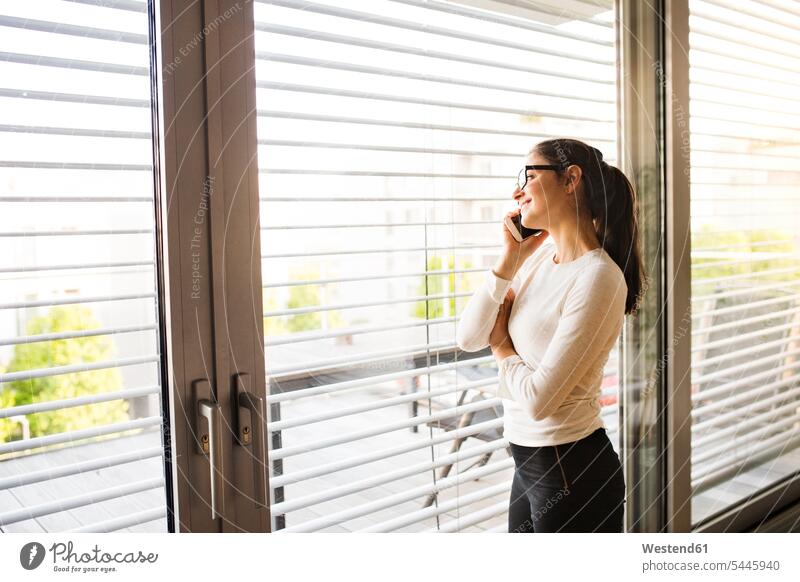 Woman on the phone looking out of the window call telephoning On The Telephone calling woman females women telephone call Phone Call using phone Using Phones