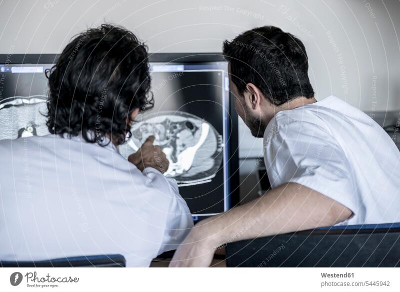 Two doctors discussing x-ray image on computer screen Medical X-Ray discussion colleagues physicians x-raying physical examination Medical Exam