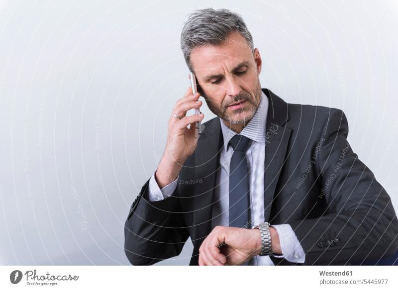 Businessman talking on the phone and checking the time expertise competence competent Head and shoulders upper body Head And Shoulder Head Shot call telephoning