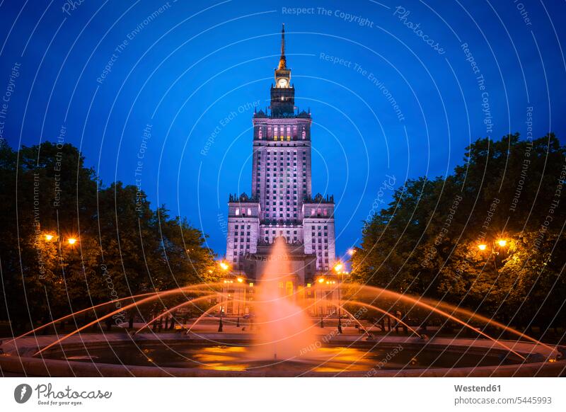 Poland, Warsaw, Palace of Culture and Science at night and fountain in Swietokrzyski Park illuminated lit lighted Illuminating outdoors outdoor shots