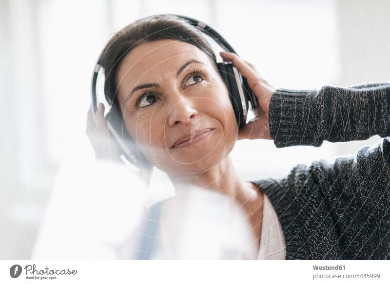 Portrait of smiling woman listening music with headphones headset portrait portraits females women Adults grown-ups grownups adult people persons human being