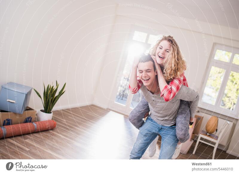 Playful young couple in new home laughing Laughter Fun having fun funny flat flats apartment apartments twosomes partnership couples positive Emotion Feeling