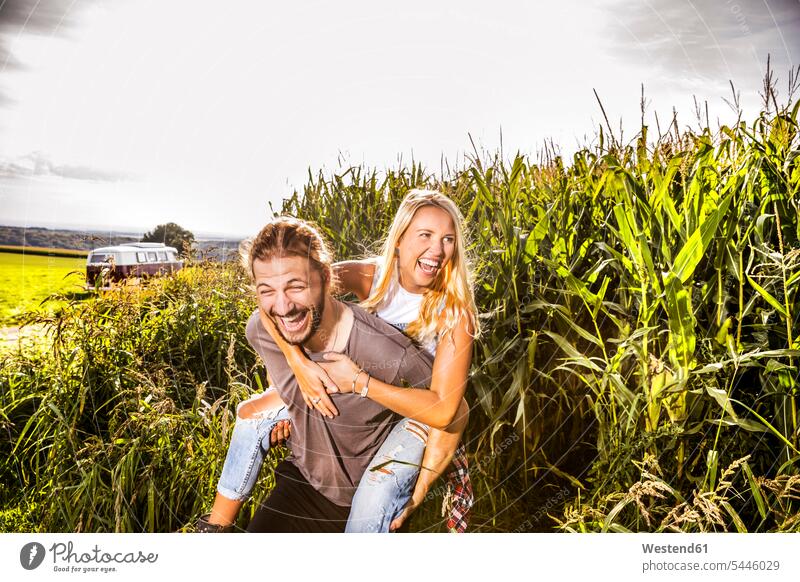 Carefree couple in cornfield Fun having fun funny rural country countryside twosomes partnership couples van laughing Laughter piggyback piggy-back pickaback