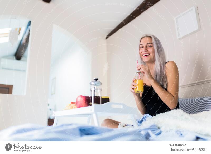 Happy young woman having breakfast in bed beds females women happiness happy Breakfast Adults grown-ups grownups adult people persons human being humans