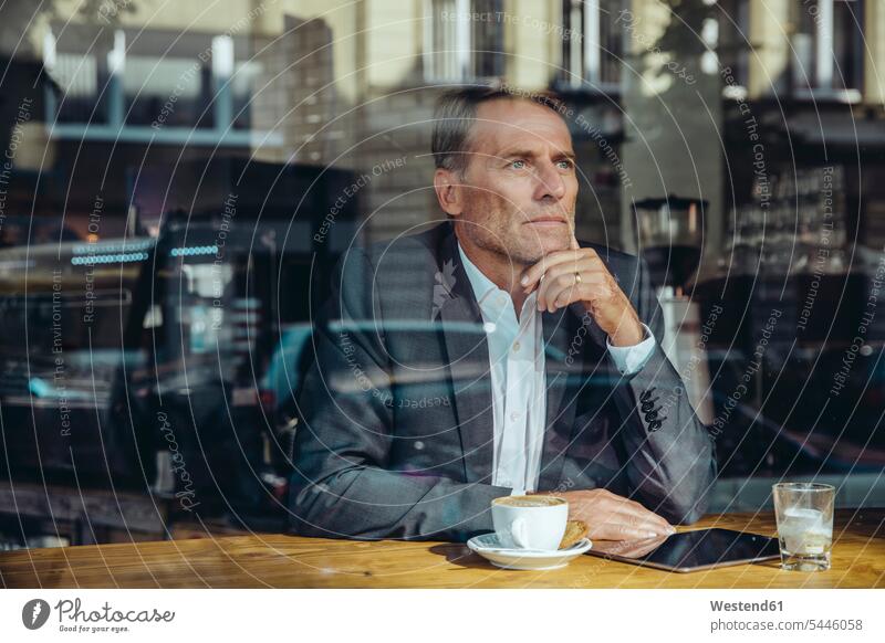 Serious businessman in cafe looking out of window Businessman Business man Businessmen Business men serious earnest Seriousness austere tablet digitizer