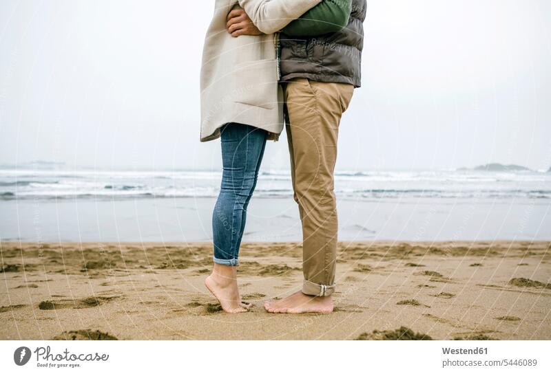 Low section of couple standing barefoot on the beach beaches twosomes partnership couples people persons human being humans human beings leg legs human leg