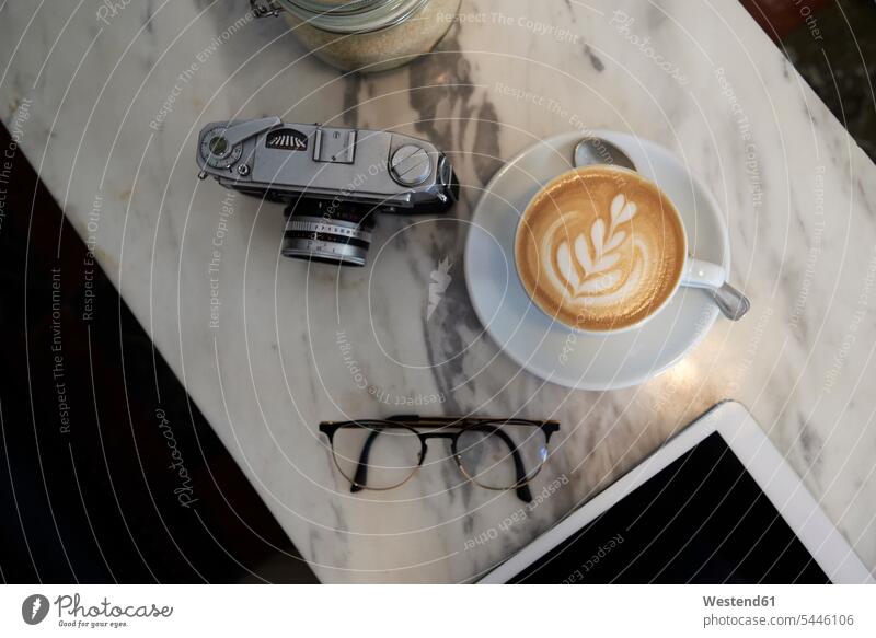 From above view of a coffee cup analogue camera and glasses on a marble table milk froth accessibility accessible Froth frothy symbolical picture Symbolism