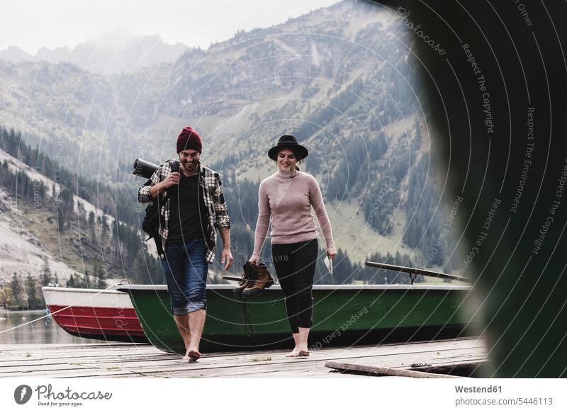 Austria, Tyrol, Alps, couple walking on jetty at mountain lake twosomes partnership couples lakes going people persons human being humans human beings water