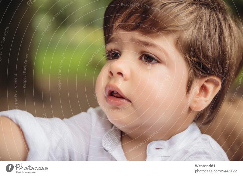 Portrait of unhappy toddler with tear in his eye boy boys males tears waterdrops teardrops tear drops portrait portraits child children kid kids people persons