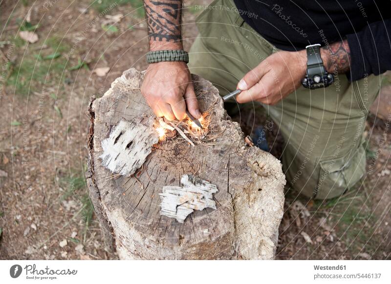 Man igniting a fire on tree stump in the forest tattoo tattoos lighting man men males woods forests Tree Stump Tree Stumps tattooed style stylish Adults