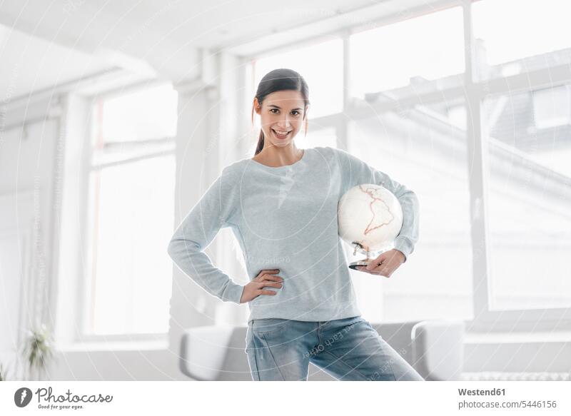 Young woman holding globe, planning world trip females women Travel vacation Holidays globes loft lofts international young Adults grown-ups grownups adult