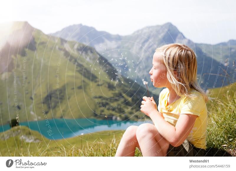 Austria, South Tyrol, young blond girl blowing blowball Lightness light Wish Wishes wishing blond hair blonde hair confidence confident dandelion clocks