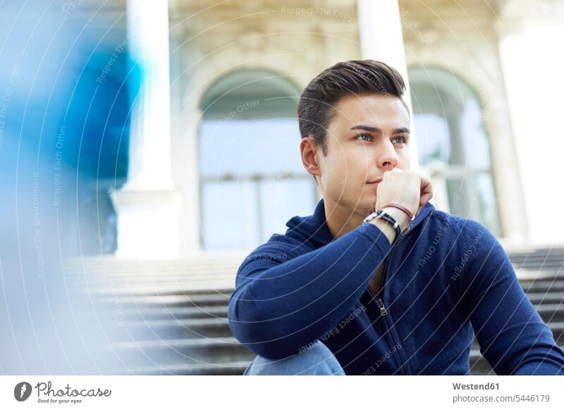 Portrait of pensive young man sitting on stairs men males portrait portraits Adults grown-ups grownups adult people persons human being humans human beings