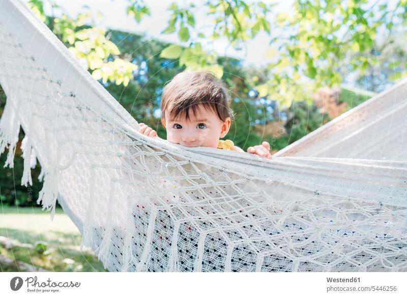 Spain, Baby girl relaxing in a hammock in the garden in the summer leisure free time leisure time cute twee Cutie lying laying down lie lying down summer time