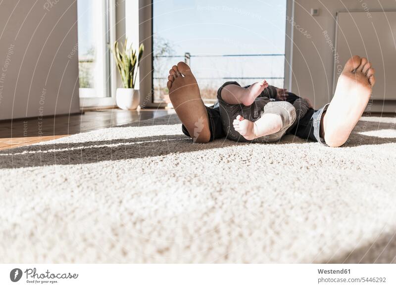 Father and baby son sleeping on carpet, view of bare feet home at home father pa fathers daddy dads papa resting asleep relaxation relaxed relaxing babies