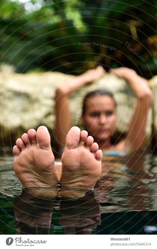 Feet of young woman relaxing in natural pool females women relaxed relaxation water Adults grown-ups grownups adult people persons human being humans