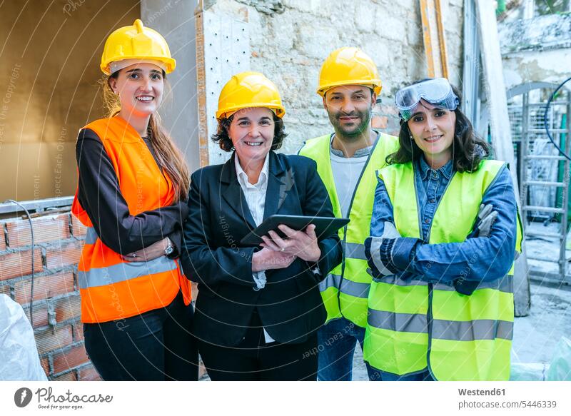Portrait of three women and a man on construction site Building Site sites Building Sites construction sites smiling smile construction worker builders