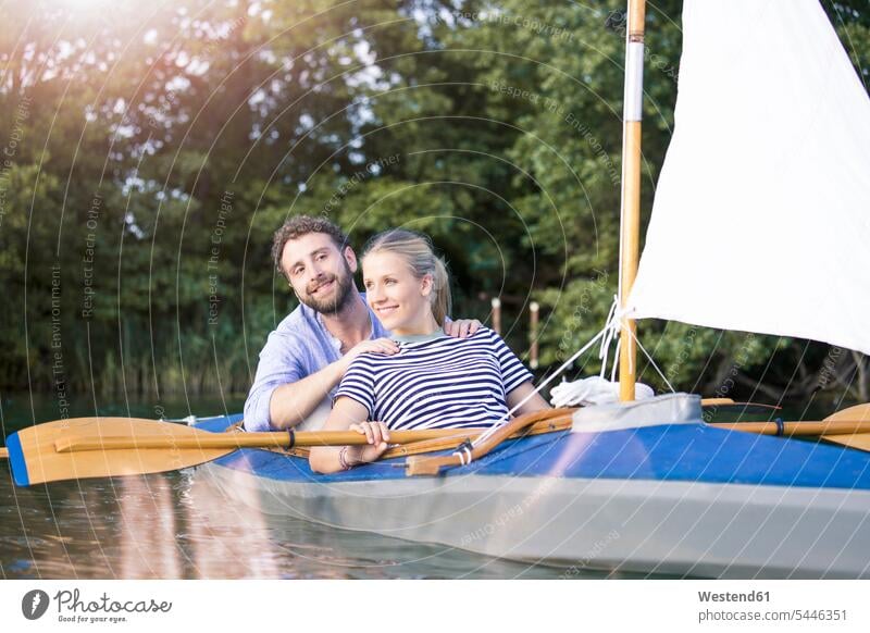 Happy young couple enjoying a trip in a canoe with sail twosomes partnership couples happiness happy excursion Getaway Trip Tours Trips indulgence enjoyment