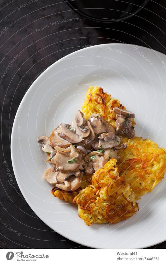 Potato rostis with champignons in cream sauce on plate overhead view from above top view Overhead Overhead Shot View From Above Swiss Food delicacy specialty