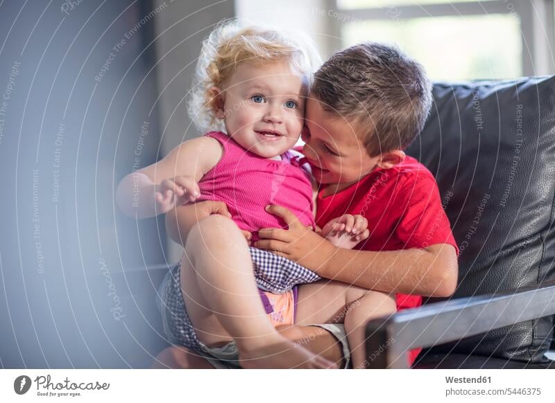 Brother and baby girl on armchair having fun home at home Arm Chairs armchairs Fun funny brother brothers siblings brother and sister brothers and sisters