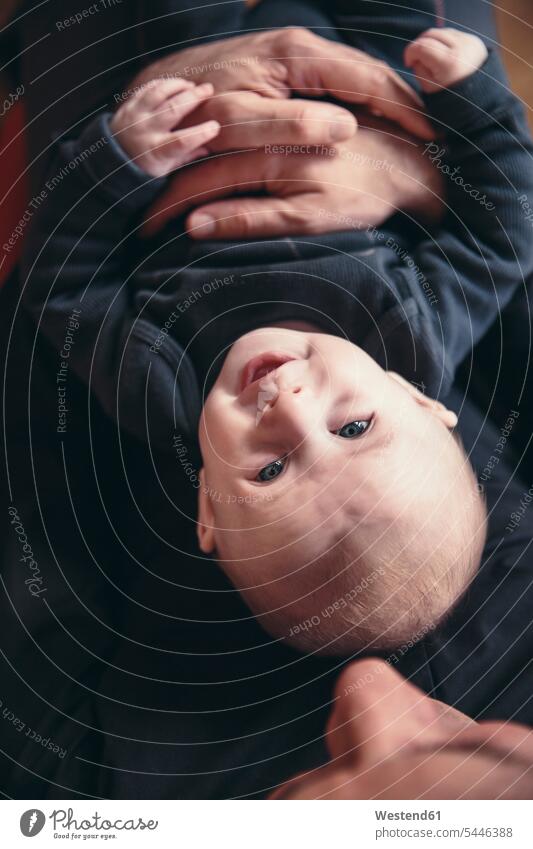 Three-month-old baby being held by father as seen from above pa fathers daddy dads papa portrait portraits infants nurselings babies holding parents family