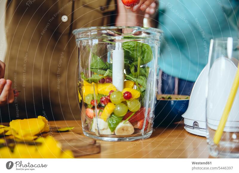 Close-up of mother and children putting fruit into a smoothie blender kitchen Smoothies mommy mothers ma mummy mama mixer Electric Mixer mixers food mixer Drink