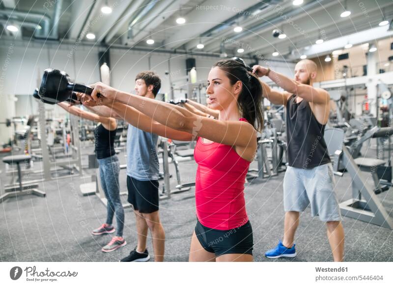 Group of athletes exercising with kettlebells in gym exercise training practising gyms Health Club fitness sport sports Fitness four people 4