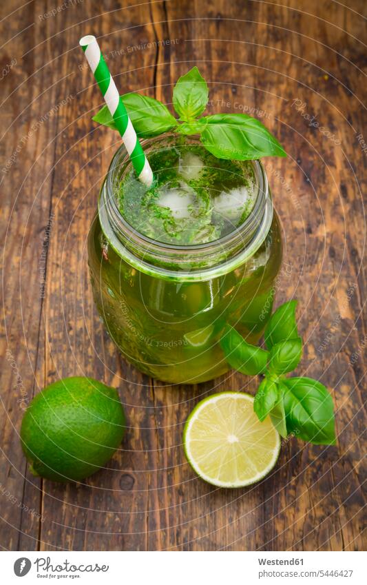 Glass of organic lime lemonade with basil Glasses wooden half halves halved prepared aroma flavour aromatic garnished ready to eat ready-to-eat homemade