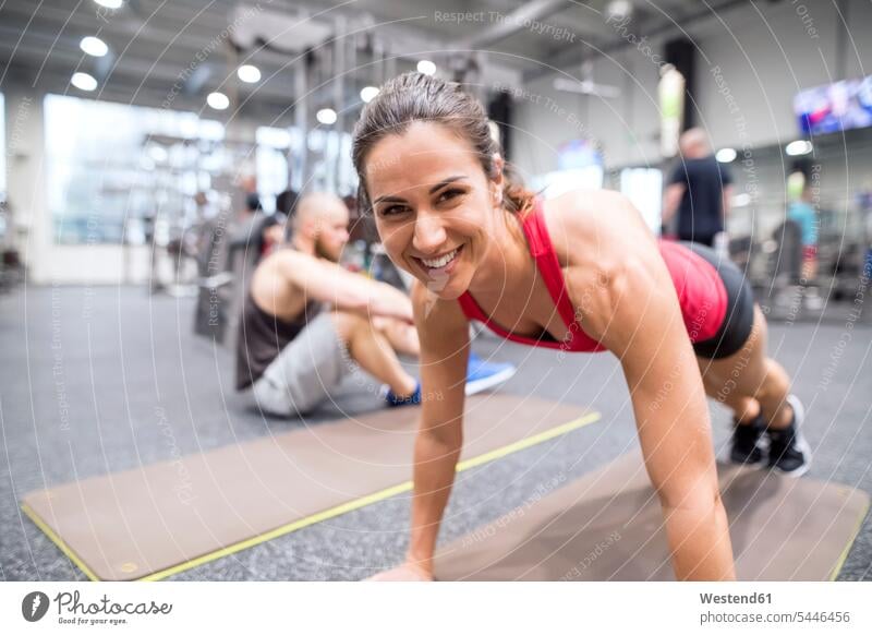 Portrait of smiling young woman exercising in gym pushup Push-up Push-ups pushups press-up press-ups Push Up Push Ups gyms Health Club exercise training
