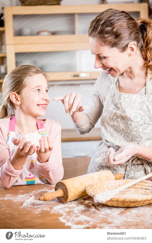 Mother and daughter baking bread in kitchen together mother mommy mothers ma mummy mama daughters domestic kitchen kitchens bake parents family families people