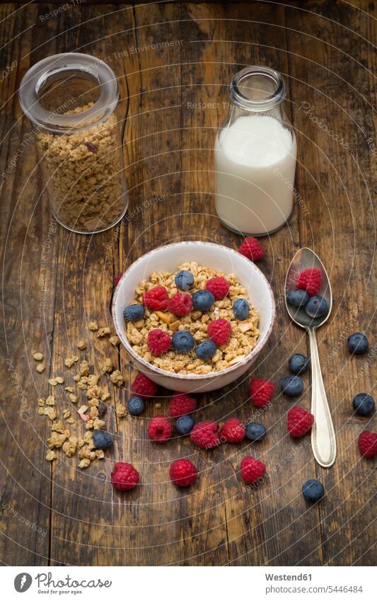 Bowl of granola with raspberries and blueberries food and drink Nutrition Alimentation Food and Drinks healthy eating nutrition Breakfast wooden