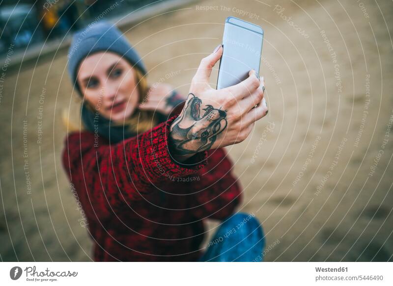 Close-up of tattooed woman's hand taking a selfie on the beach. mobile phone mobiles mobile phones Cellphone cell phone cell phones sitting Seated females women