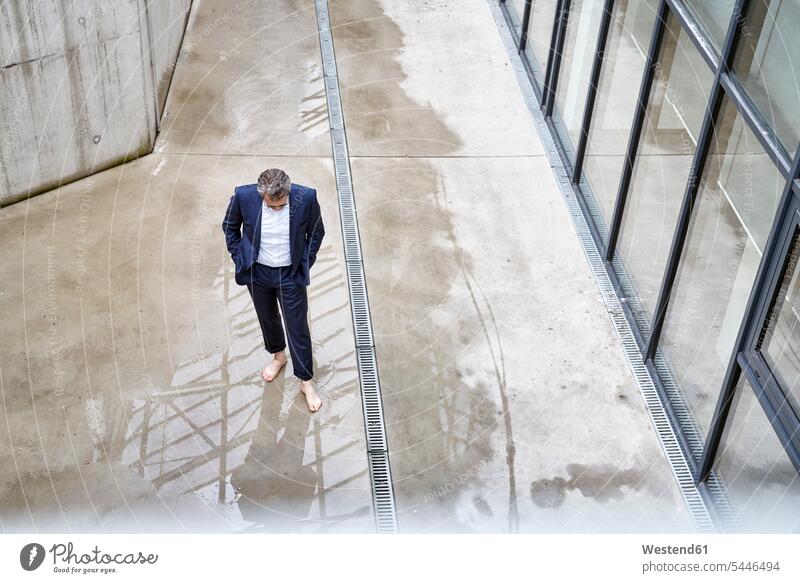 Barefoot businessman standing in a puddle Businessman Business man Businessmen Business men puddles pool business people businesspeople business world