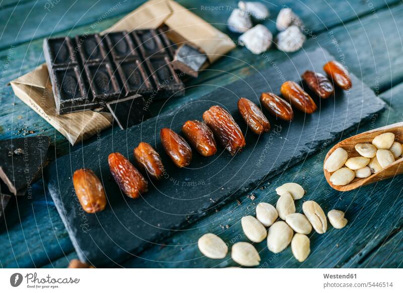 Dates, dark chocolate, almonds and dried figs on wood dried fruit Dried Fruits Arrangement Positioning Positionings Arrangements bitter chocolate arrangement