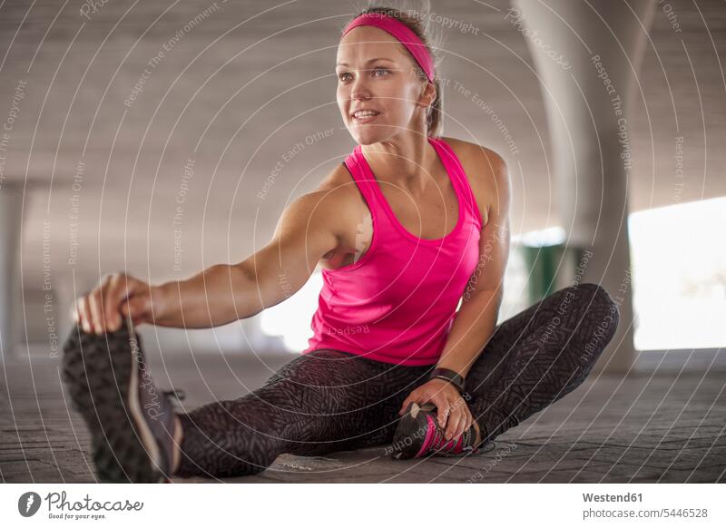 Sportive woman sitting and stretching exercising exercise training practising sportive sporting sporty athletic females women Seated sports Adults grown-ups