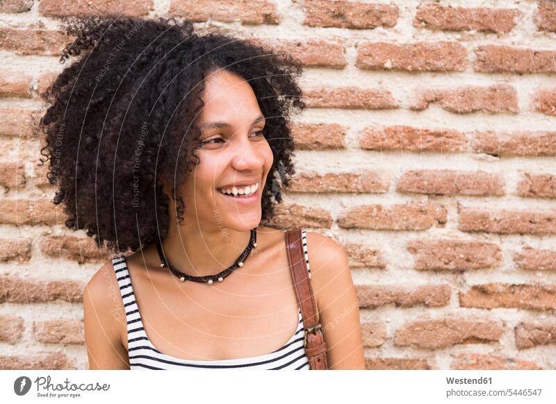 Portrait of smiling woman in front of brick wall portrait portraits females women Adults grown-ups grownups adult people persons human being humans human beings