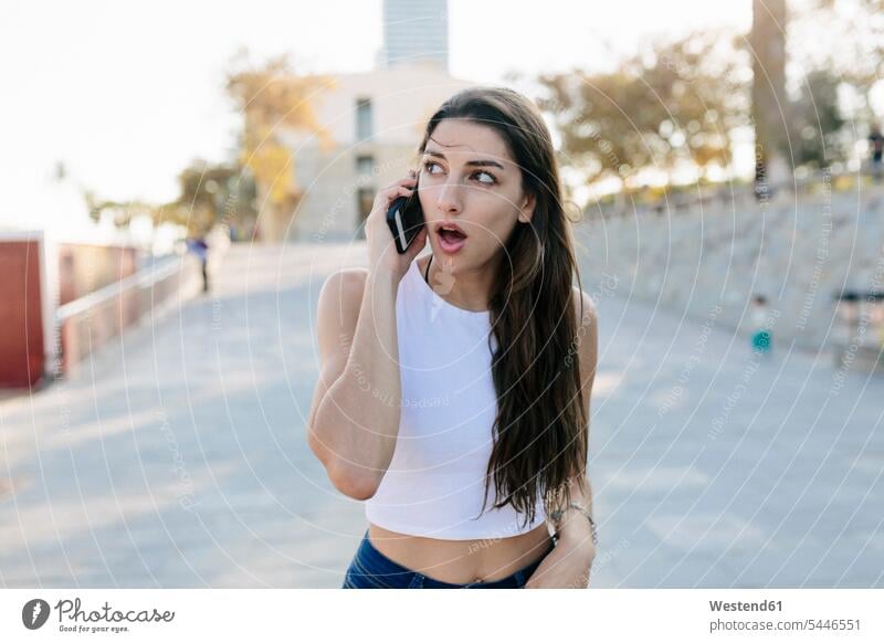 Portrait of astonished young woman on the phone females women portrait portraits Smartphone iPhone Smartphones Adults grown-ups grownups adult people persons