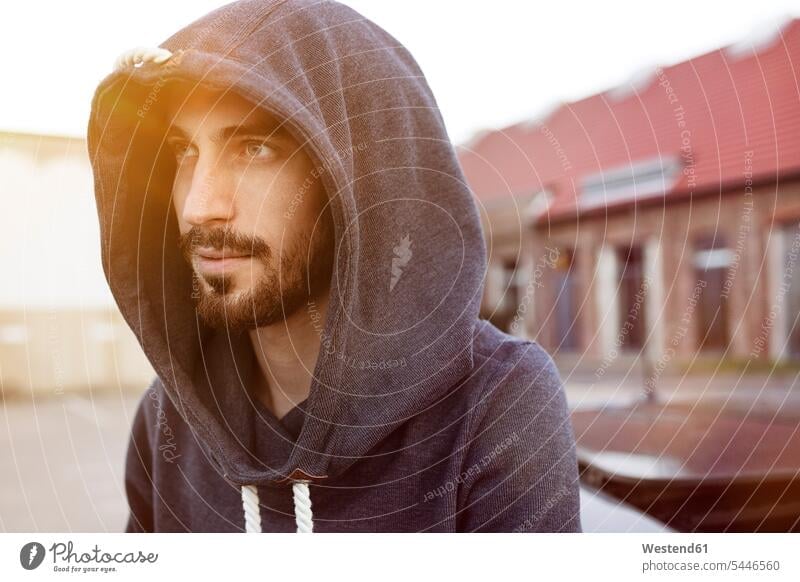 Portrait of bearded young man wearing hooded jacket hoods men males portrait portraits Adults grown-ups grownups adult people persons human being humans